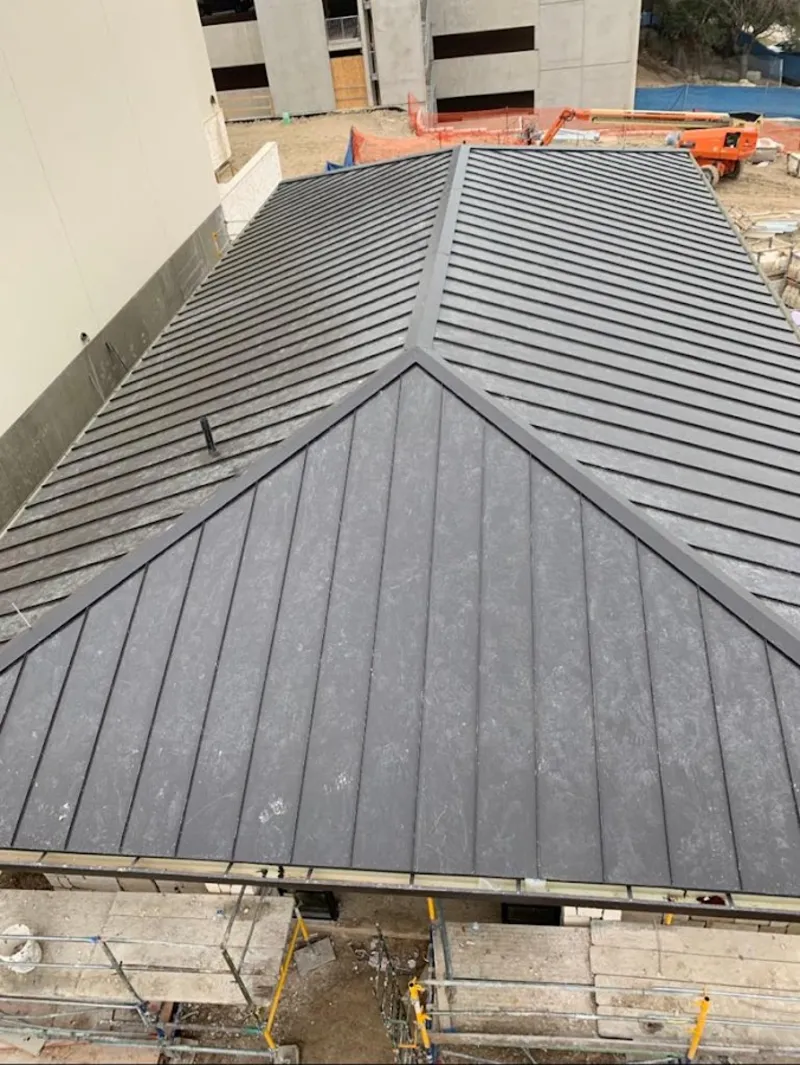 Commercial metal roof construction with crane equipment in Whitfield